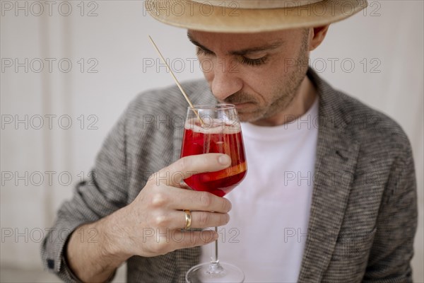 Man with a hat and a glass of Aperol Spritz