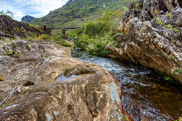 River through the vegetation of the Biribiri reserve in Diamantina with an old wooden bridge built by slaves to drain the production of diamonds and destroyed by time