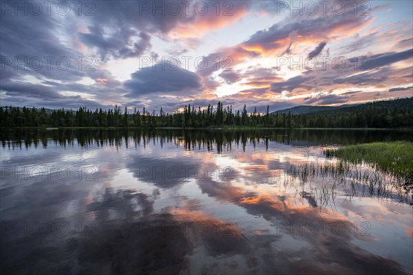 Dramatic sunset by the river Namsen with reflection