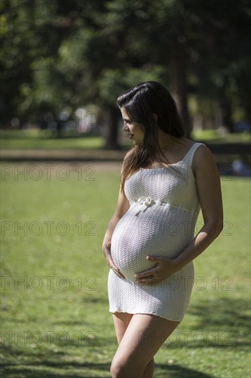 Portrait of pregnant latina woman in a park