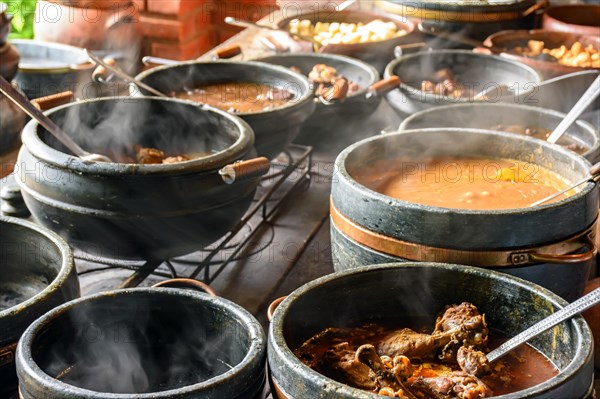 Typical Brazilian foods placed in clay pots and on a metal plate of a traditional wood stove