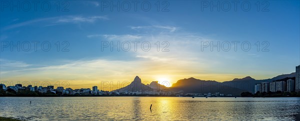 Panoramic photograph of Rodrifgo de Freitas lagoon during sunset with its waters and hills in the neighborhoods of Ipanema and Leblon
