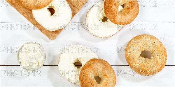 Bagel sandwich for breakfast topped with cream cheese on wooden board Panorama from above in Stuttgart