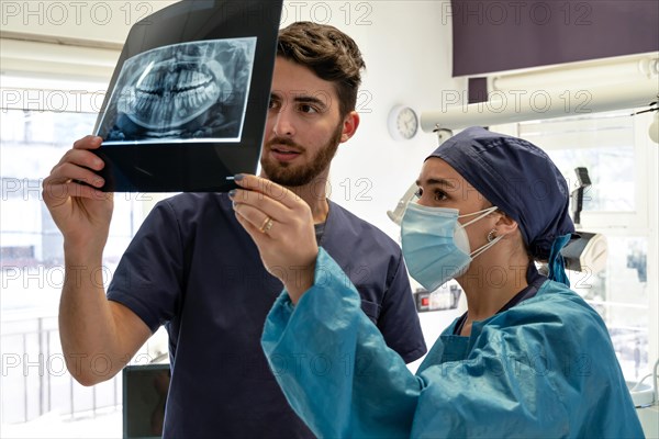 Two experienced dentists x-ray examination of a human jaw in the dental office