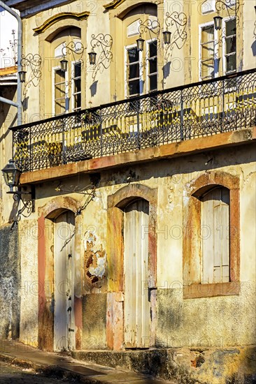 Facade of old house in colonial architecture worn by time in the city of Ouro Preto