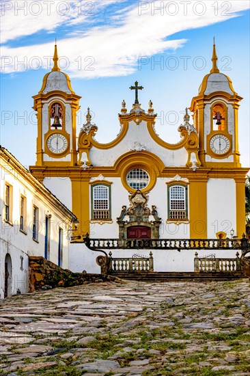 Facade of a historic church in baroque style built in the 18th century cobblestone street with houses in the city of Tiradentes in Minas Gerais
