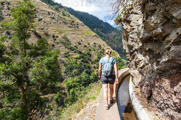 Young woman hiking along the Levada Nova hiking trail on Madeira Island