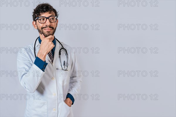 Pensive doctor man looking side isolated. Young doctor thinking and looking side isolated