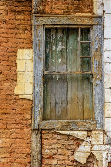 Old wooden window ruined by time on the facade of abandoned house in the historic city of Diamantina in Minas Gerais