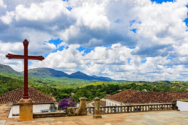 View of the city and mountains of the historic city of Tiradentes in the state of Minas Gerais from the churchyard with its crucifix