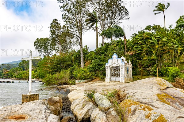 Small and old chapel on the rocks by the sea in Ilhabela island on the north coast of Sao Paulo