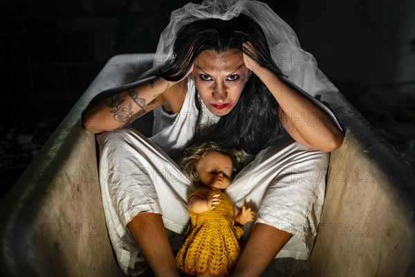 Deranged bride with a doll in a bathtub. Inspired by the traditional American legend of la llorona