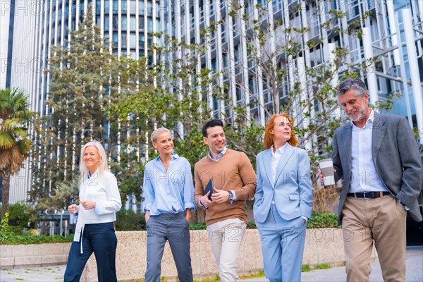Group of coworkers walking going to work outdoors in a corporate office area