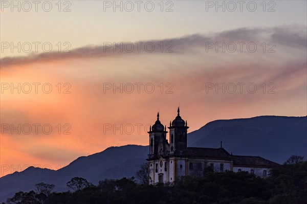 Old and historic 18th century church with its facade illuminated by sunset in the city of Ouro Preto