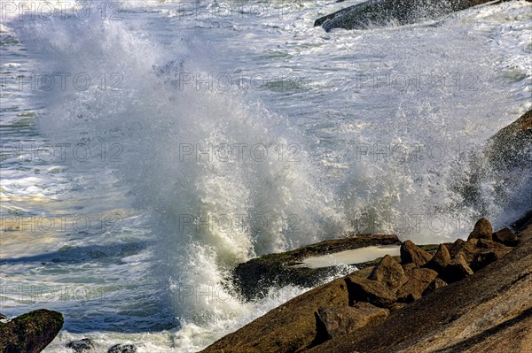 Sea water splashing into the air as waves crash against rocks