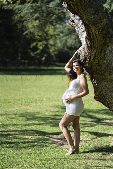 Portrait of pregnant latina woman in a park