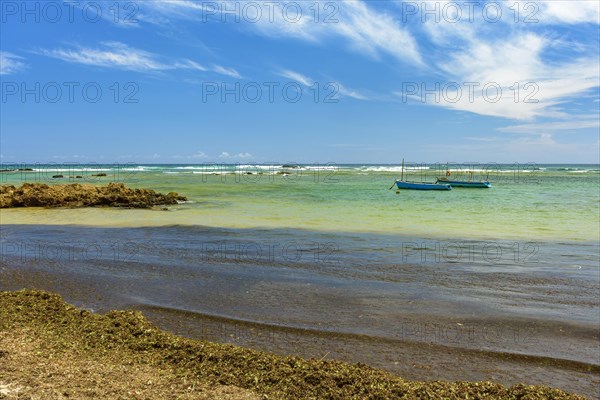 Fishing boats on the colorful waters of Itapua beach in Salvador