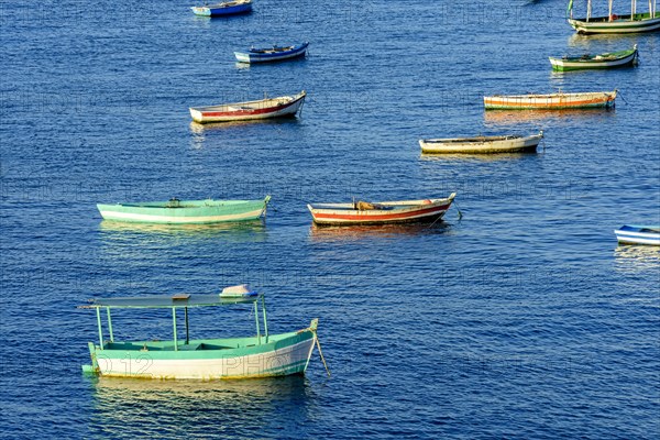 Rustic wooden fishing boats in the sea of the city of Salvador in Bahia