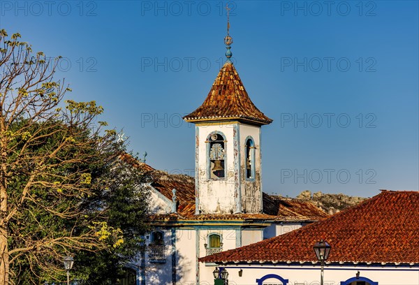 Baroque church bell tower with rising through the trees and roofs of the historic town of Diamantina in Minas Gerais