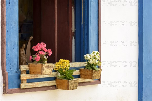 Window decorated with flowers and objects in the historic city of Tiradentes typical of the interior of the state of Minas Gerais