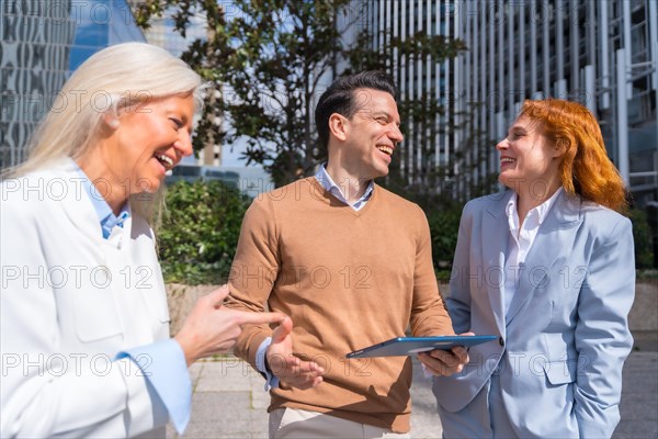 Group executives or businessmen and businesswoman in a business area. Laughing and looking at a tablet