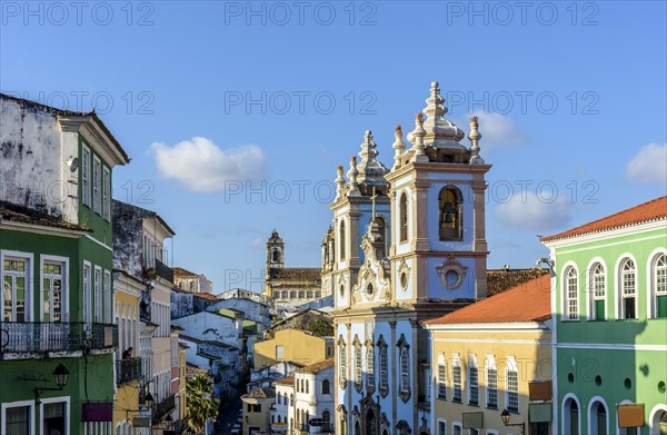 Colorful and ancient colonial houses facades and historic church towers in baroque and colonial style with blue sky in the famous Pelourinho district of Salvador