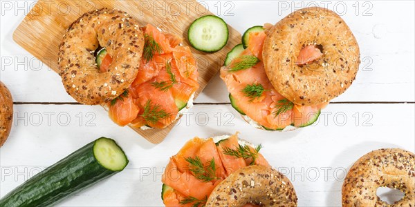 Bagel sandwich for breakfast topped with salmon fish from above on a wooden board Panorama in Stuttgart