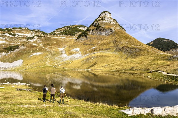 The Austrian alphorn trio Klangholz plays the alphorn at the Augstsee on Mount Loser