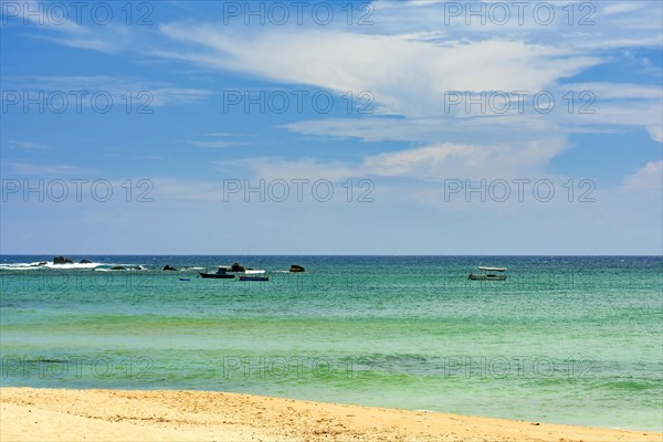 Wooden fishing boats on the colorful waters of Itapua beach in Salvador