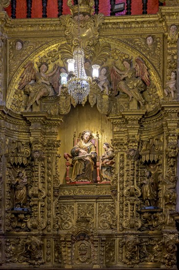 Interior of a baroque church decorated with images of saints and walls with gold leaf ornaments in the historic city of Ouro Preto