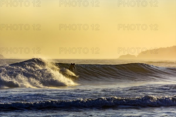 Silhouette of surfer on Ipanema beach during summer sunset