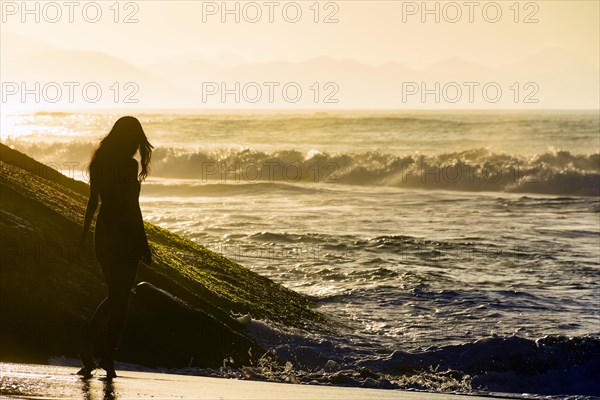Young girl silhuette at summer sunrise in Ipanema beach