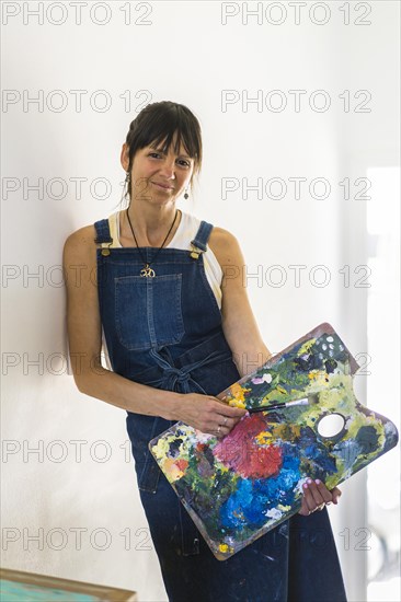 Portrait of a woman artist leaning on the wall