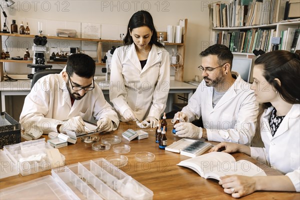 Laboratory team of life science researchers. Talking and working in the lab room on a scientific project