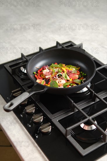 Frying fresh vegetables and shrimps in a frying pan