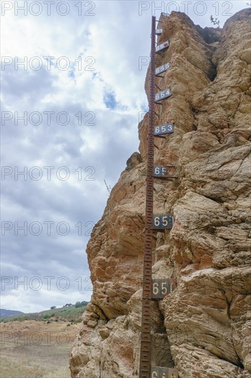 Metal water level gauge in a reservoir emptied by drought and climate change