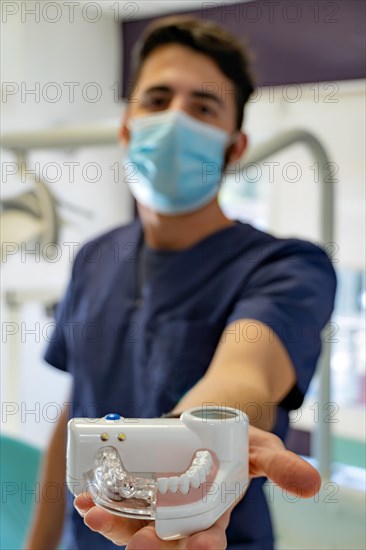 Young male doctor dentist in dark blue uniform