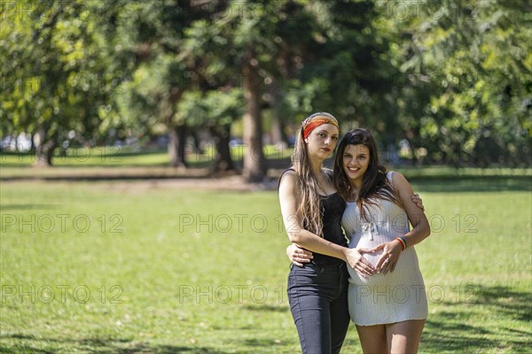 Happy pregnant lesbian couple at outdoors. LGBT