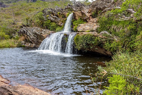 Waterfall between the rocks and vegetation of Serra do Biribiri state park in Diamantina