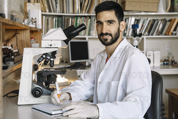 Young scientist in front of microscope