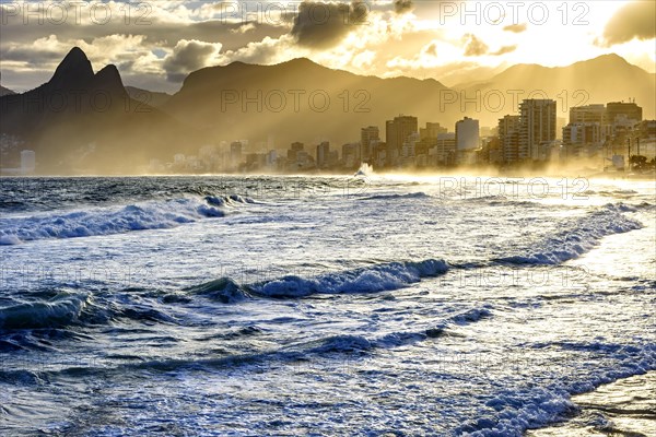 Summer sunset with cloudy sky with Two Brothers hill and Vidigal slum view from Ipanema beach at Rio de Janeiro