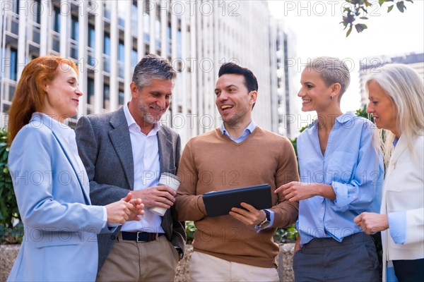 Chatting and seeing work stuff on a tablet. Group executives or businessmen and businesswoman in a business area