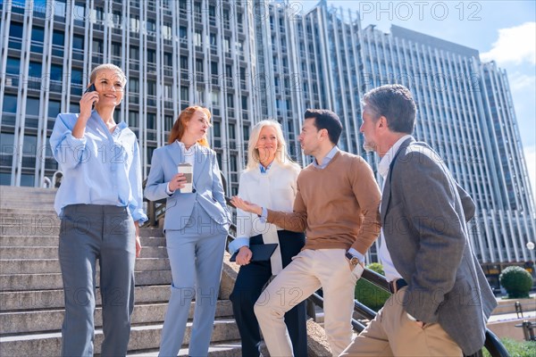 Speaking in a relaxed moment at halftime. Group of coworkers outdoors in a corporate office area