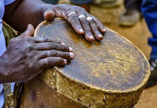 Percussionist playing a rudimentary atabaque during afro-brazilian cultural manifestation