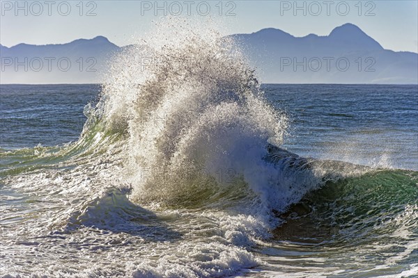 Wave breaking at Ipanema beach in Rio de Janeiro with water splashing into the air