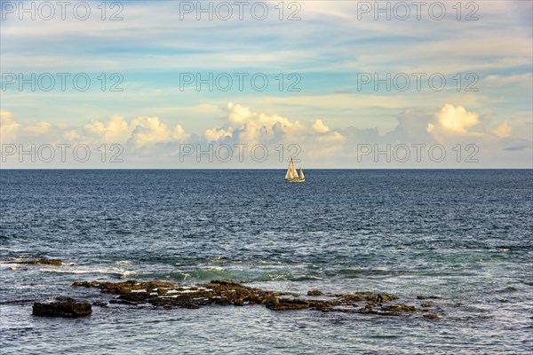 Sailboat sailing during the evening in the Bay of All Saints