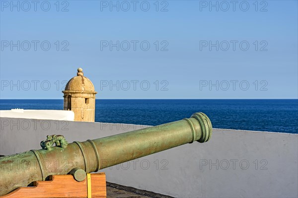 Old iron cannon and guardhouse on the strong walls of the historic fortress of Farol da Barra in the city of Salvador