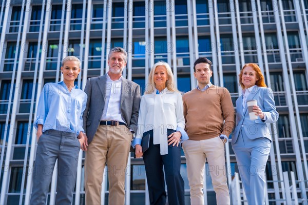 Portrait of cheerful group of coworkers walking outdoors in a corporate office area