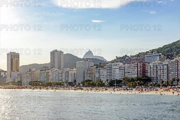 Sunny day at Copacabana Beach in Rio De Janeiro with the slum and the statue of Christ the Redeemer in the background