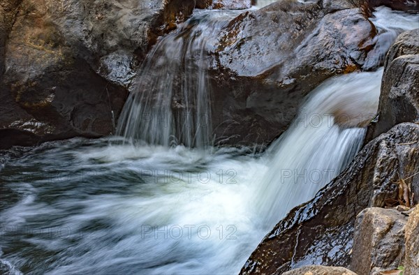 Small creek with clear waters and casacade running through the rocks of the mountains of Minas Gerais